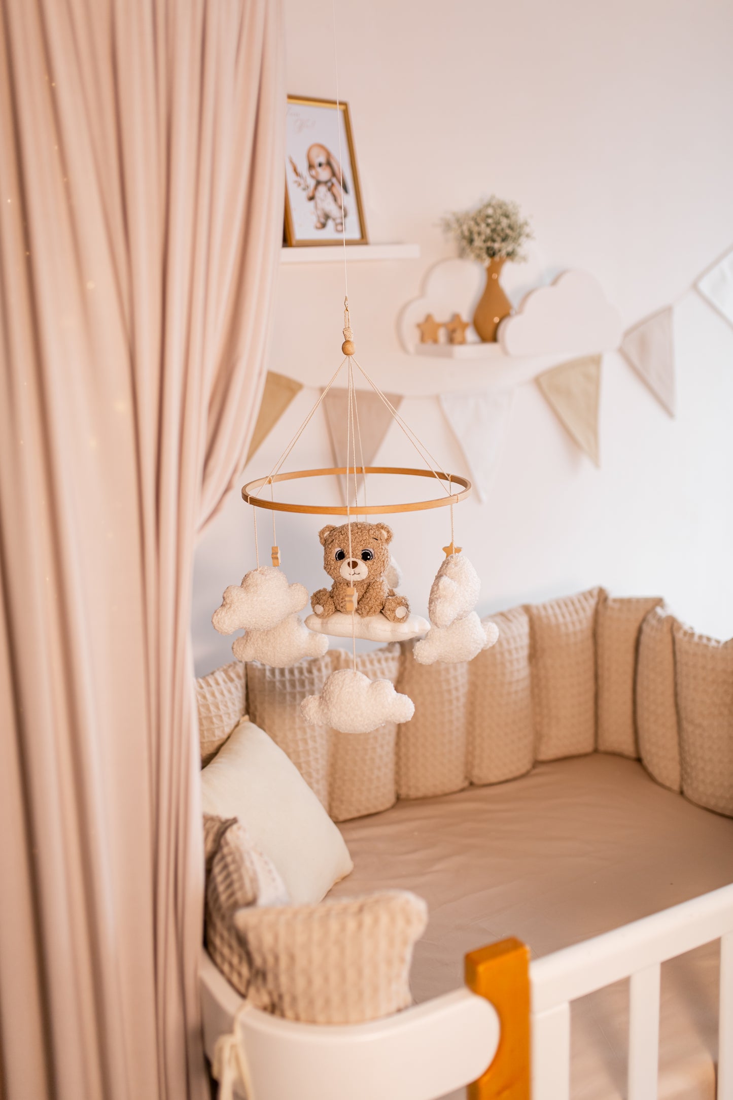 Nursery room with crib, teddy bear baby mobile and decorative elements.