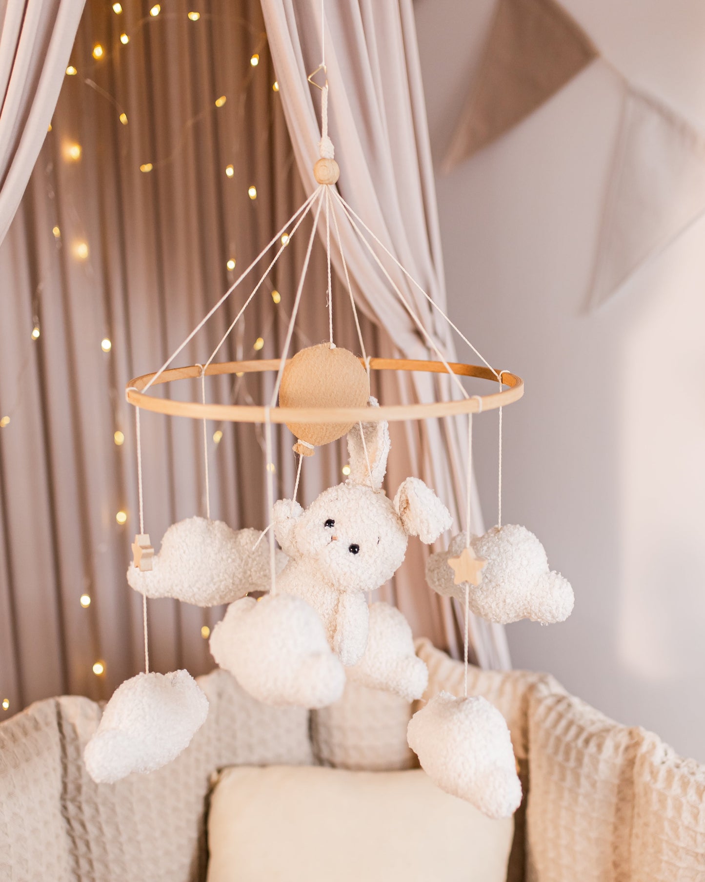 Boucle bunny baby mobile floating on balloons and clouds above crib