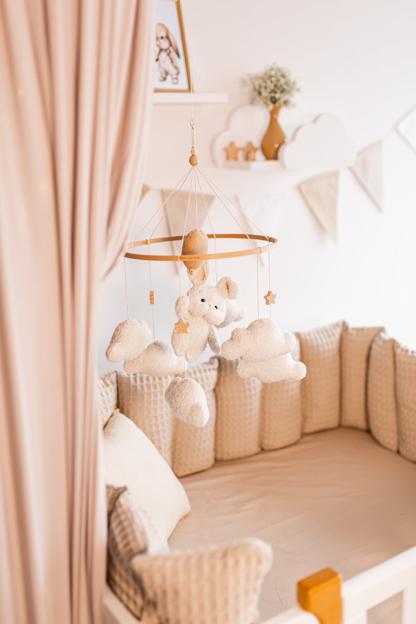 Nursery room with crib, teddy bear, and hanging baby mobile