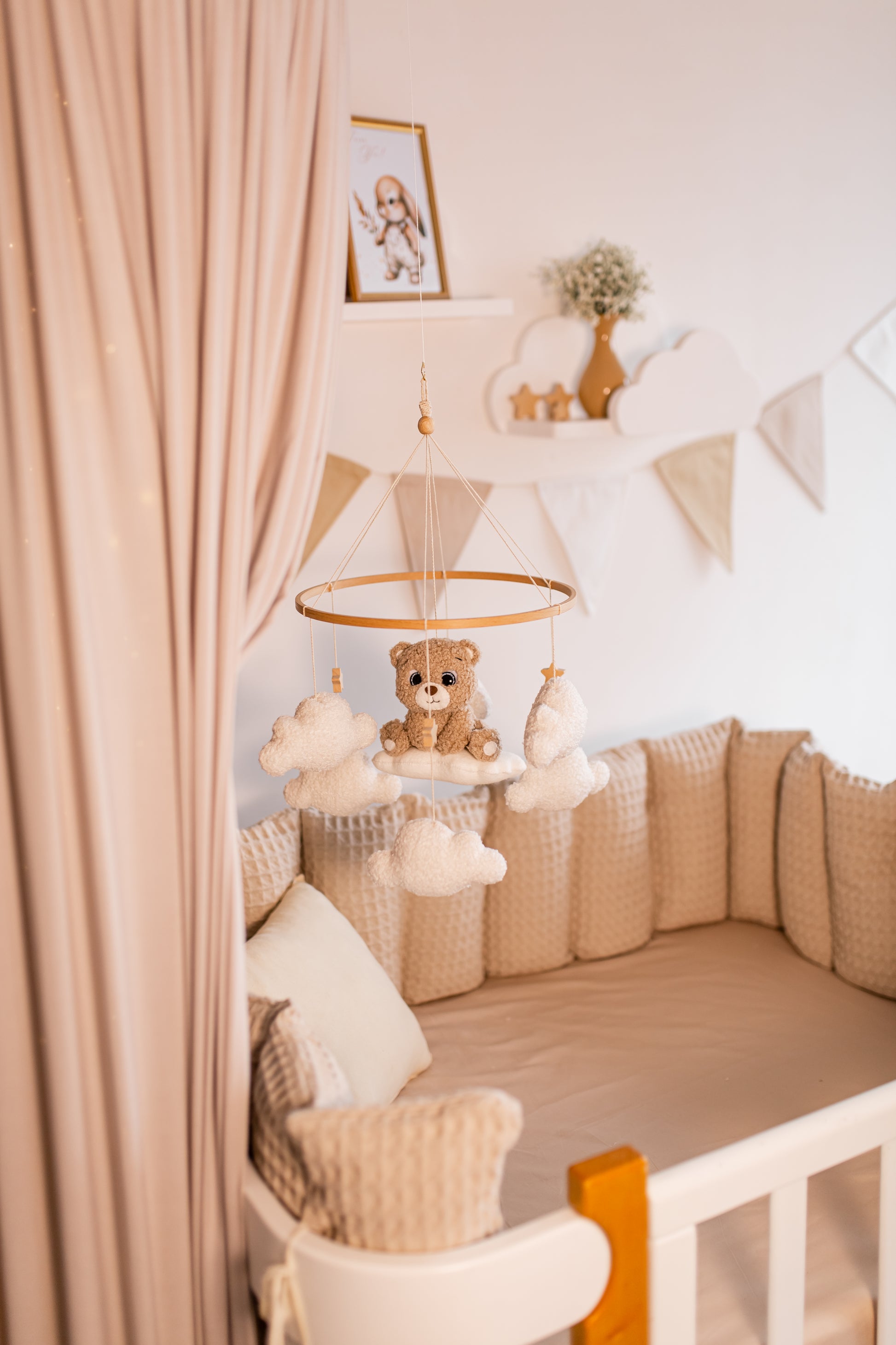 Nursery room with crib, teddy bear baby mobile and decorative elements.