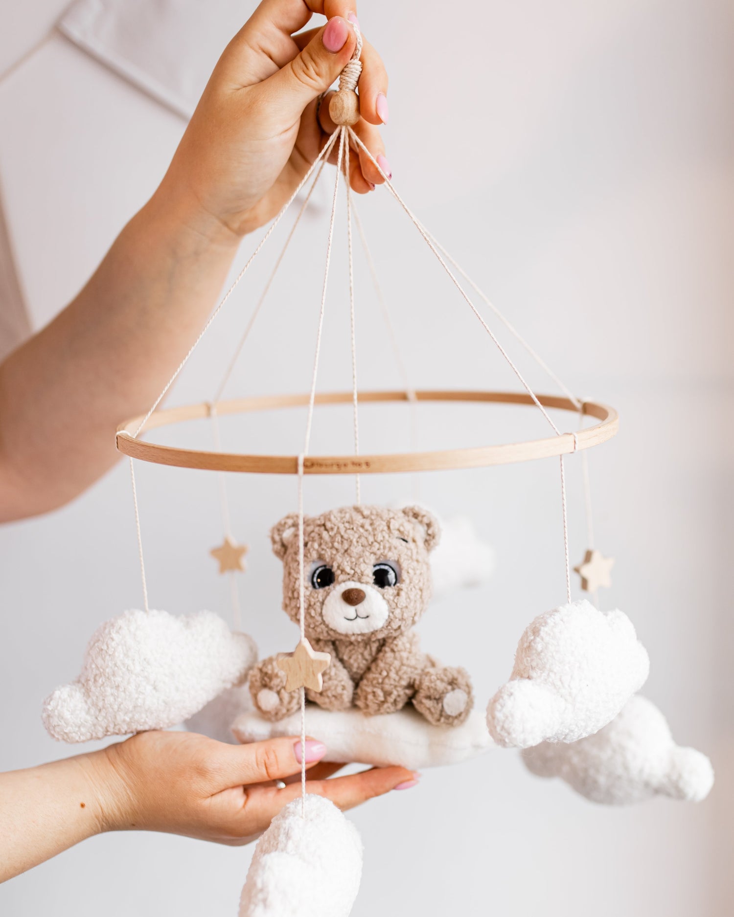 Boucle bear baby mobile with stars and clouds hanging above crib