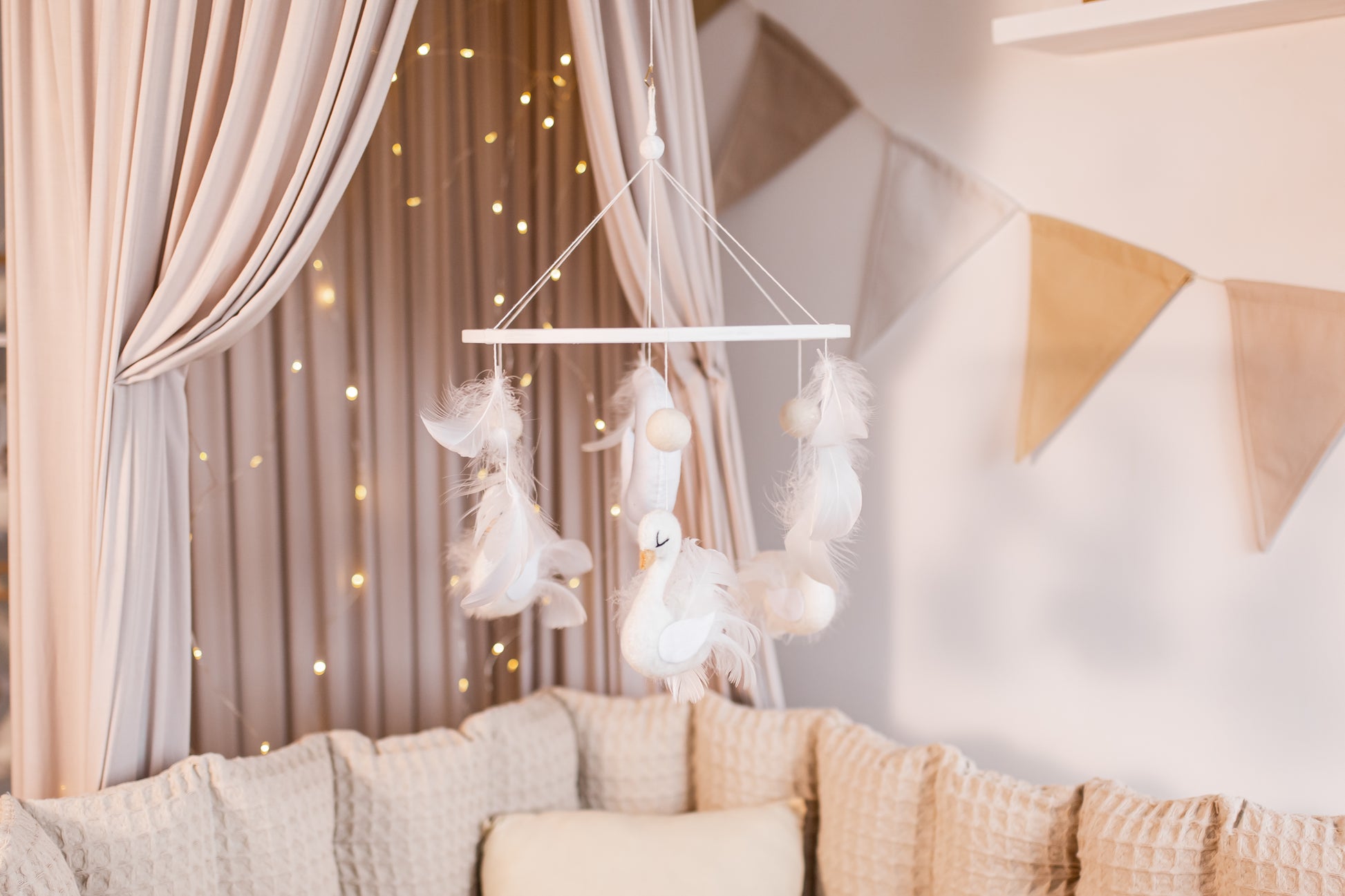 Decorative mobile hanging above a sofa with soft lighting and neutral colors